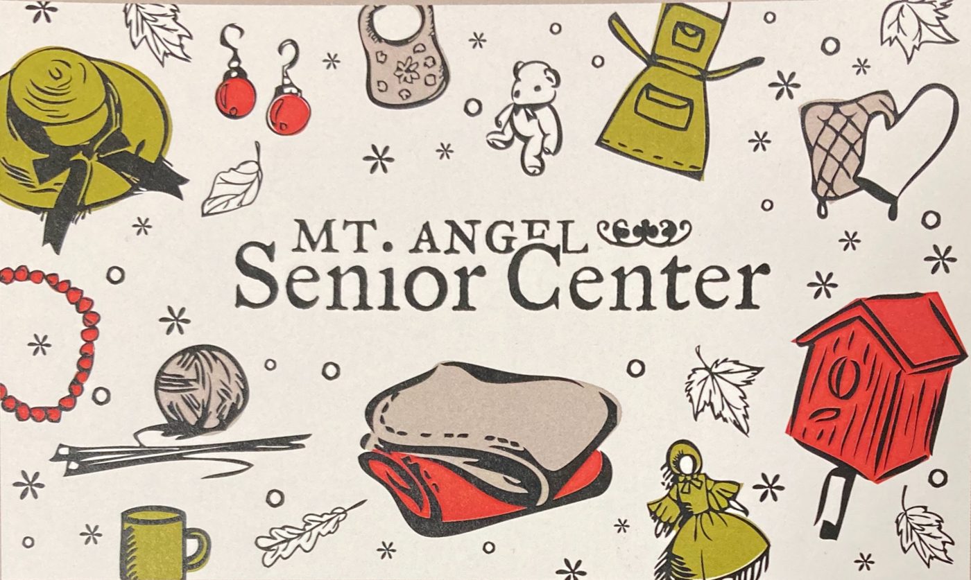 The center’s printed card: a woodcut-style illustration of a sun hat, ball of yarn and knitting needles, a coffee mug, a folded quilt, a red birdhouse, an apron, earrings and autumn leaves around the words Mt. Angel Senior Center.